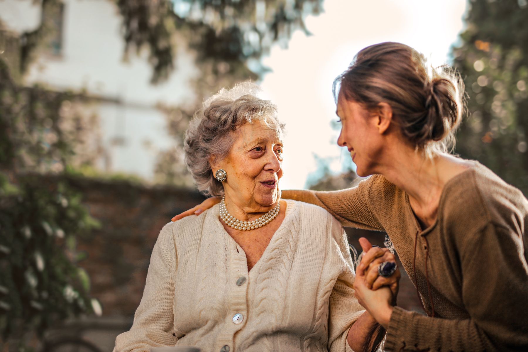 An older woman in warm afternoon light, sharing a quiet, unhurried moment